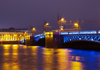Fototapeta na wymiar St. Petersburg at night. View of the Palace Bridge and the Neva River with color reflection of street lighting in the water. Beautiful evening cityscape