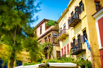 Fototapeta na wymiar Cozy old greek building with greenery lit by warm soft sun.