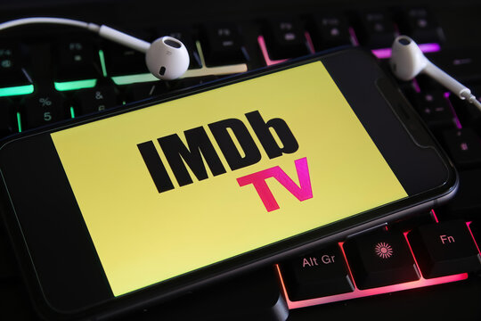 Viersen, Germany - March 1. 2021: Closeup of mobile phone screen with logo lettering of streaming service imdb tv on laptop keyboard