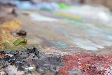 Artist's palette with mixed oil paints bottom view in perspective, abstract art background texture