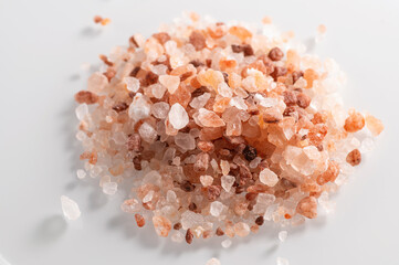 pink Himalayan coarse salt on a white background, close-up, top view