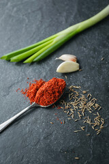 The spices are shot with a strong shot. Red pepper on a teaspoon, close-up, cheskock, onion