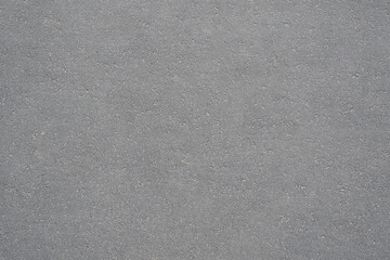 Textured background of dry, gray asphalt, outside. Sidewalk top view