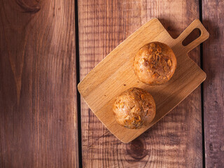 Two cakes with nut and honey balls on a small wooden plank top view