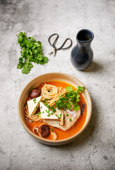 Asian fish noodle soup with tofu, greens and  shiitake mushrooms