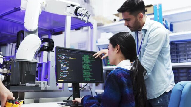 Concept of virtual reality, simulation, Robot arm and future technology.Asian Engineers Maintenance Robot Arm at Lab. they are in a High Tech Research Laboratory with Modern Equipment. 