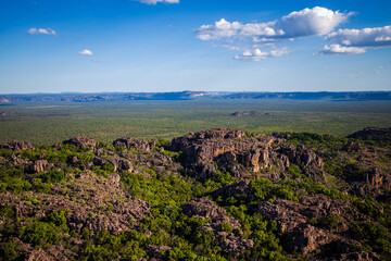 awesome view from a helicopter on green forest, mountains and bright blue sky