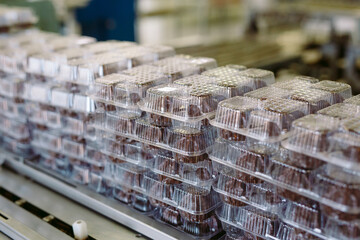 Packaged sweets in plastic containers. Confectionery factory.