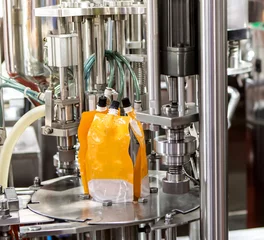 Fototapete Saft Food liquid nozzle packaging machine. Orange juice pouch filling machine. Food industry  © Itsanan