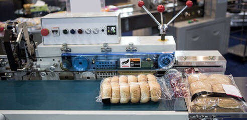 Automatic packing of bakery product flow pillow packing machine. Bread, toast, bun plastic wrapping...