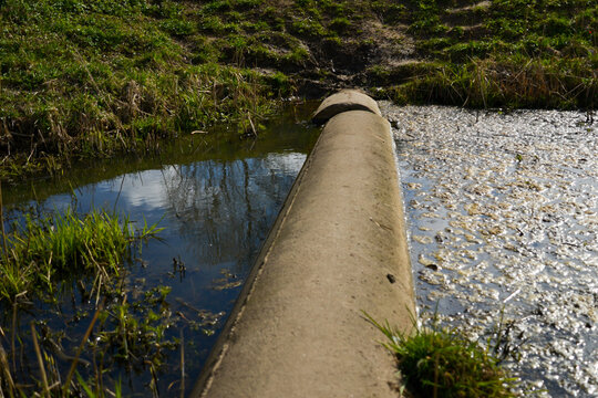 concrete ditch in a ditch with dirty water.