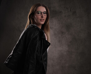 Close-up of a young attractive woman against dark grey background - studio photography