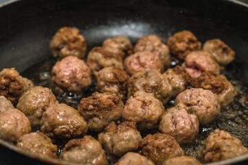 Meat balls are fried in a frying pan in oil. The cooking process. Delicious food.