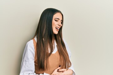 Beautiful brunette young woman wearing casual clothes with hand on stomach because nausea, painful disease feeling unwell. ache concept.