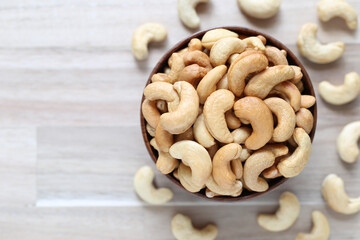 Top view of Roasted cashew nuts in a bowl on wooder background, Healthy eating concept