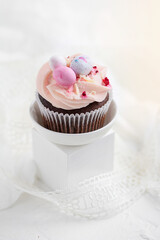 Easter chocolate cupcake with caramel filling and decoration in the form of small Easter eggs from marzipan