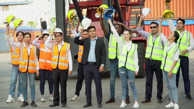 group of happy and confident diversity containers worker standing and holding hard hat up to celebrate to success at warehouse logistic in Cargo freight ship for import export.