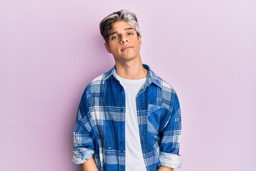 Young hispanic man wearing casual clothes relaxed with serious expression on face. simple and natural looking at the camera.