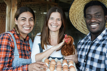 Multiracial people with chicken and fresh ecologic eggs - Multi generational farmer at work