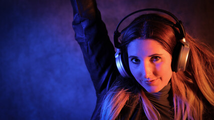 Young pretty woman listens to music - strong colorful close-up shot - studio photography