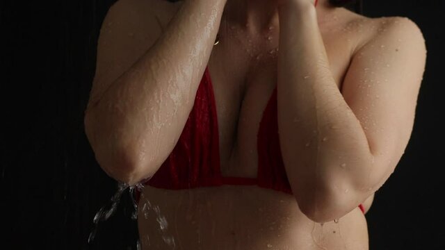 Crop seductive woman in bra taking shower