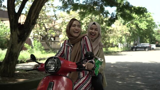 portrait of happy muslim girls riding scooter enjoy summer vacation with friends