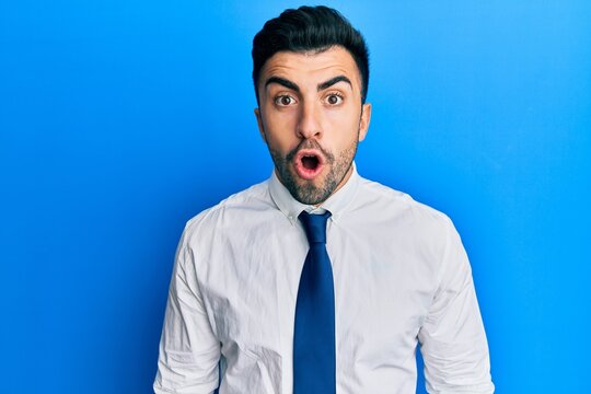 Young hispanic man wearing business clothes afraid and shocked with surprise expression, fear and excited face.