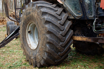 Fototapeta na wymiar Old tire of a large tractor with cracks close-up. Big wheel.