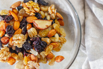 A plate with a mixture of nuts and dried fruits, raisins, walnuts, hazelnuts, almonds, cashews