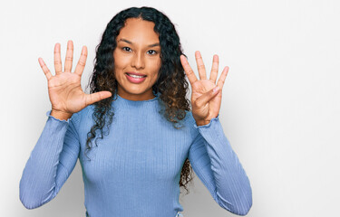 Young hispanic woman with curly hair wearing casual clothes showing and pointing up with fingers...
