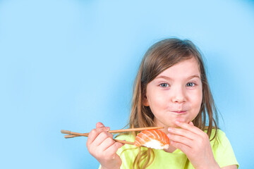 Cute little girl eating sushi