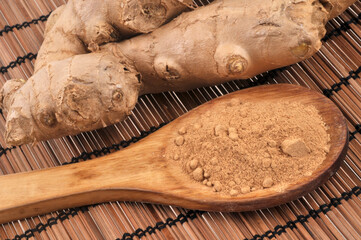 Cuillère en bois de gingembre en poudre et gingembre frais en gros plan