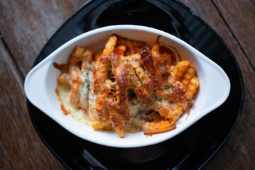 Freshly cooked French fries baked with cheese