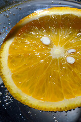 orange in sparkling water with bubbles. macro.