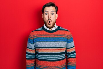 Fototapeta premium Handsome caucasian man with beard wearing elegant wool winter sweater afraid and shocked with surprise expression, fear and excited face.