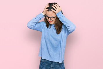 Young beautiful woman wearing casual clothes and glasses suffering from headache desperate and stressed because pain and migraine. hands on head.