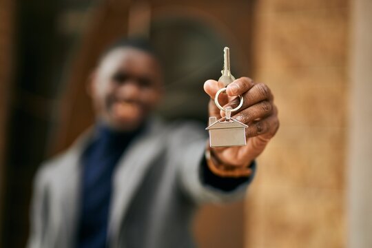 Young African American Man Smiling Happy Holding New Home Key At The City