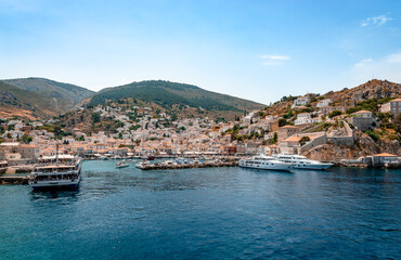 Fototapeta na wymiar View of the crescent-shaped port and the village of Hydra. Hydra is a small picturesque island in Saronic gulf and a popular tourist destination.