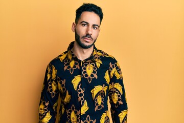 Young hispanic man wearing casual shirt relaxed with serious expression on face. simple and natural looking at the camera.