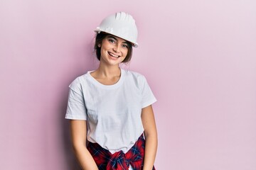 Young caucasian woman wearing hardhat with a happy and cool smile on face. lucky person.