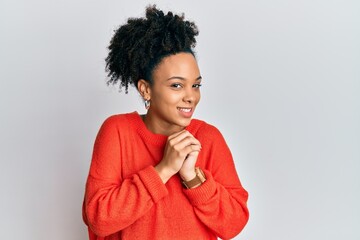 Young african american girl wearing casual clothes laughing nervous and excited with hands on chin looking to the side