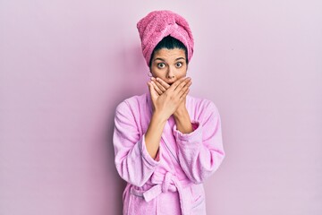 Young hispanic woman wearing shower towel cap and bathrobe shocked covering mouth with hands for mistake. secret concept.