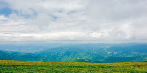 path through mountain meadow. beautiful carpathian landscape in summertime. clouds on the sky above the distant ridge. windy weather