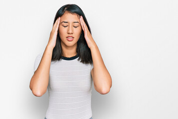 Beautiful asian young woman wearing casual white t shirt with hand on head for pain in head because stress. suffering migraine.