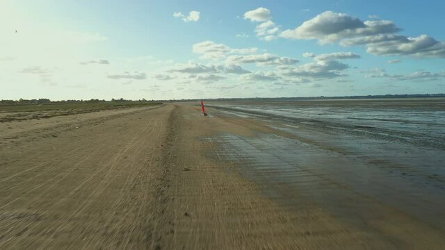 Flying a drone behind Blokarts along the shore. France. High quality FullHD footage