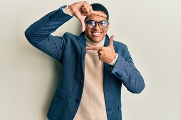 Young handsome hispanic man wearing elegant clothes and glasses smiling making frame with hands and...
