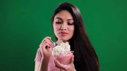 Young happy woman enjoys her bowl of ice cream - studio photography