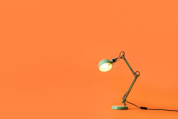Modern table lamp on color background