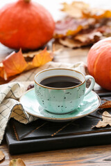 Beautiful autumn composition with cup of coffee and pumpkins on wooden background