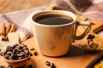 Board with cup of coffee, cinnamon sticks and beans on wooden background, closeup